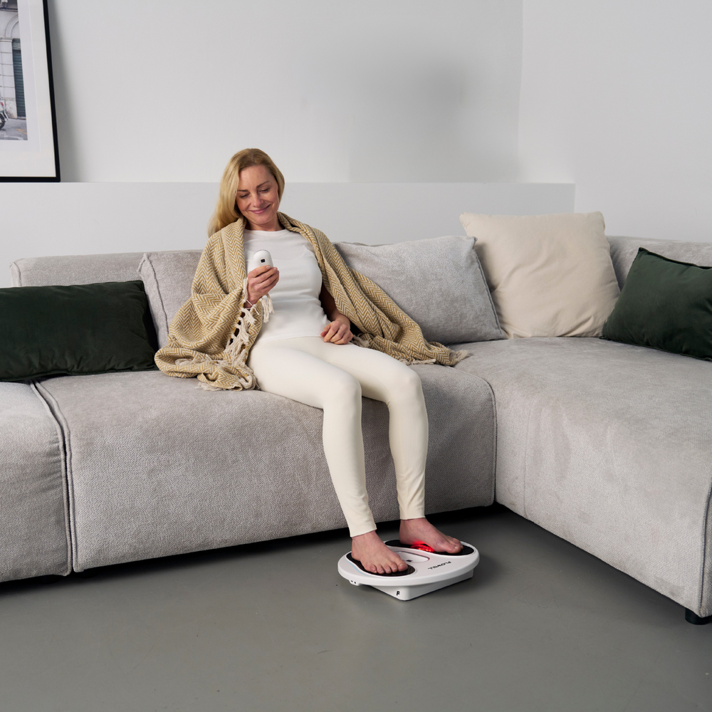 Flowell: Woman using a scale on a gray floor with a couch in the background