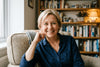Flowell: Woman sitting on a couch in a cozy room with bookshelves in the background