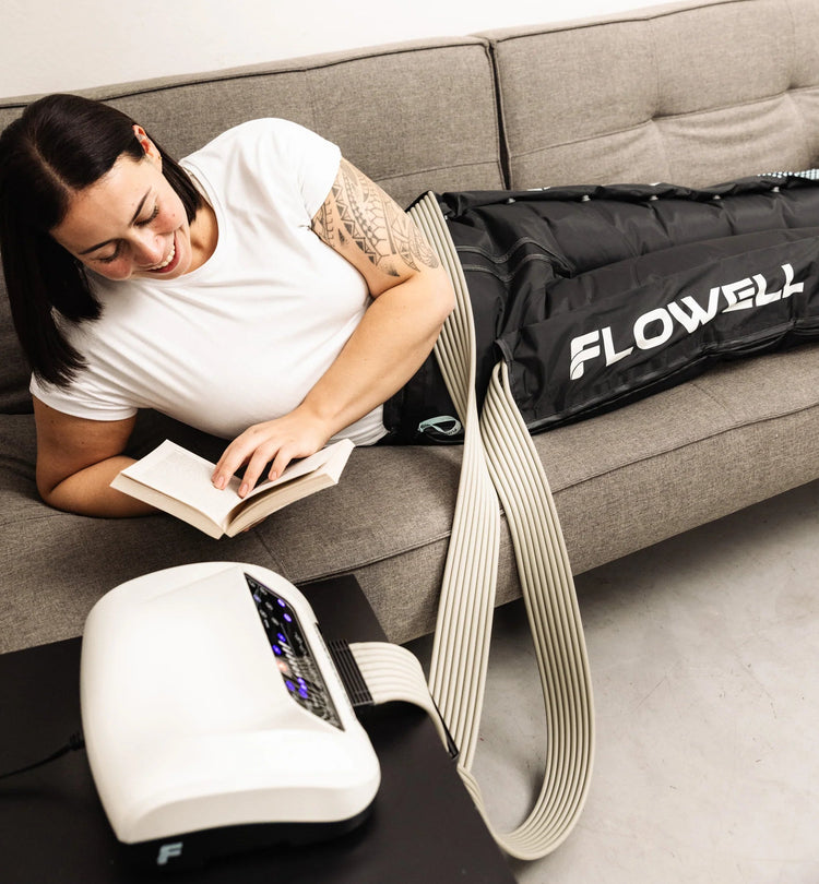 Flowell: Woman reading a book on a couch next to a Flowell device and bag