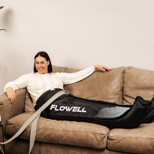 Flowell: Woman using a Flowell massage device on a couch.