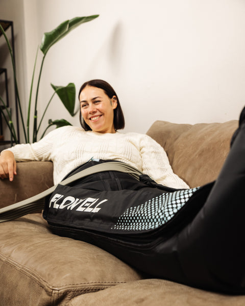 Flowell - Woman laying on a couch wearing Flowell Home Deluxe Pants with a smile