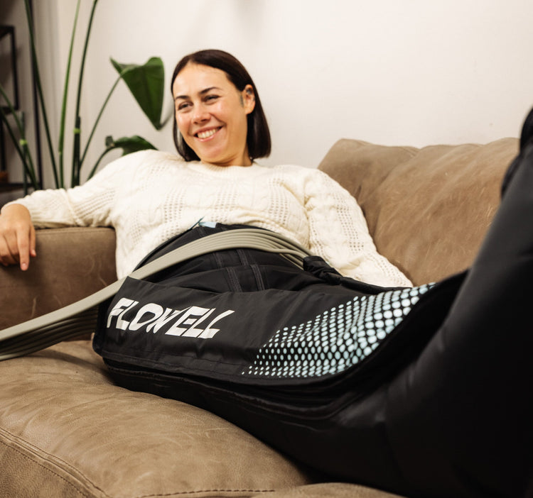 Flowell - Woman laying on a couch wearing Flowell Home Deluxe Pants with a smile