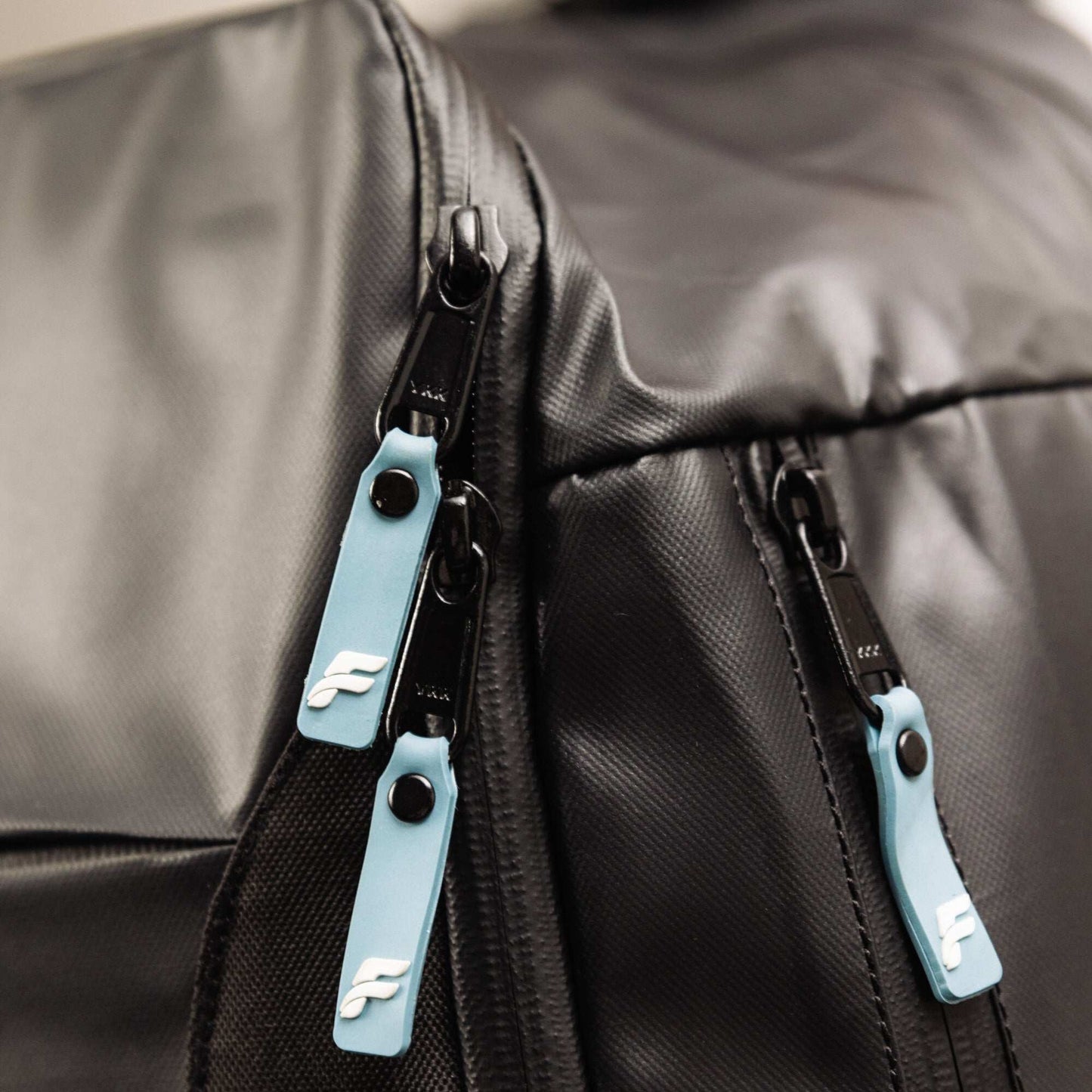 Flowell Pro Gear Backpack - Close up shot of Pro Gear Backpack's light blue and white zippers