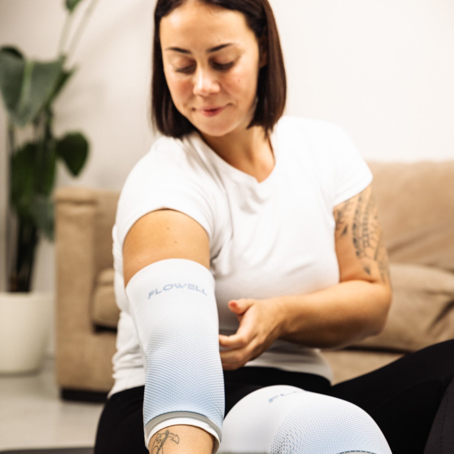 Flowell Thermosleeve - Woman wearing white and light blue Flowell thermosleeves on her elbow and her knee