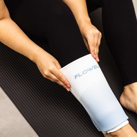 Flowell Thermosleeve - Woman pulling a white and light blue Flowell thermosleeve over her knee