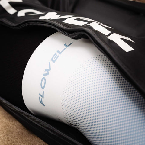 Flowell Thermosleeve - Woman wearing white and light blue Flowell thermosleeve on her knee while zipping up her Flowell Home Deluxe Pants