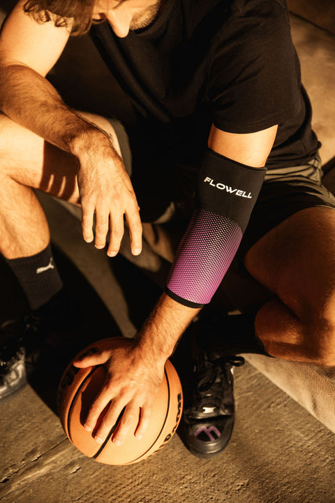 Flowell - Man crouched on the ground, holding a basketball and wearing a black and purple Flowell Thermosleeve