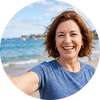 Flowell: Woman smiling on a beach with ocean and sky in the background
