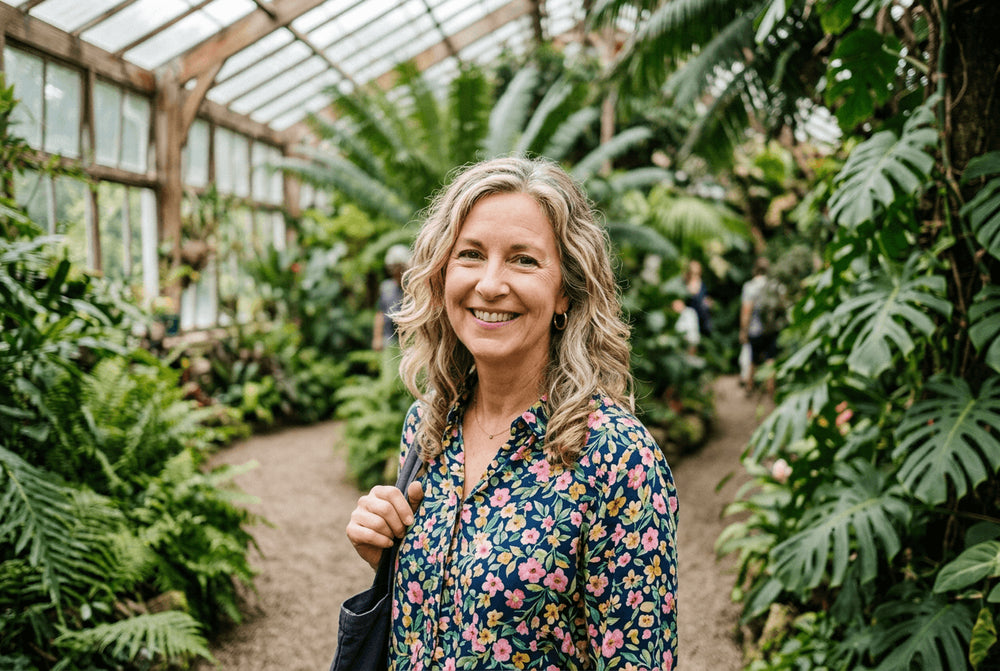 Flowell: Woman standing in a greenhouse filled with lush green plants