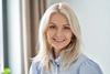 Flowell: Woman with blonde hair smiling in a neutral indoor setting